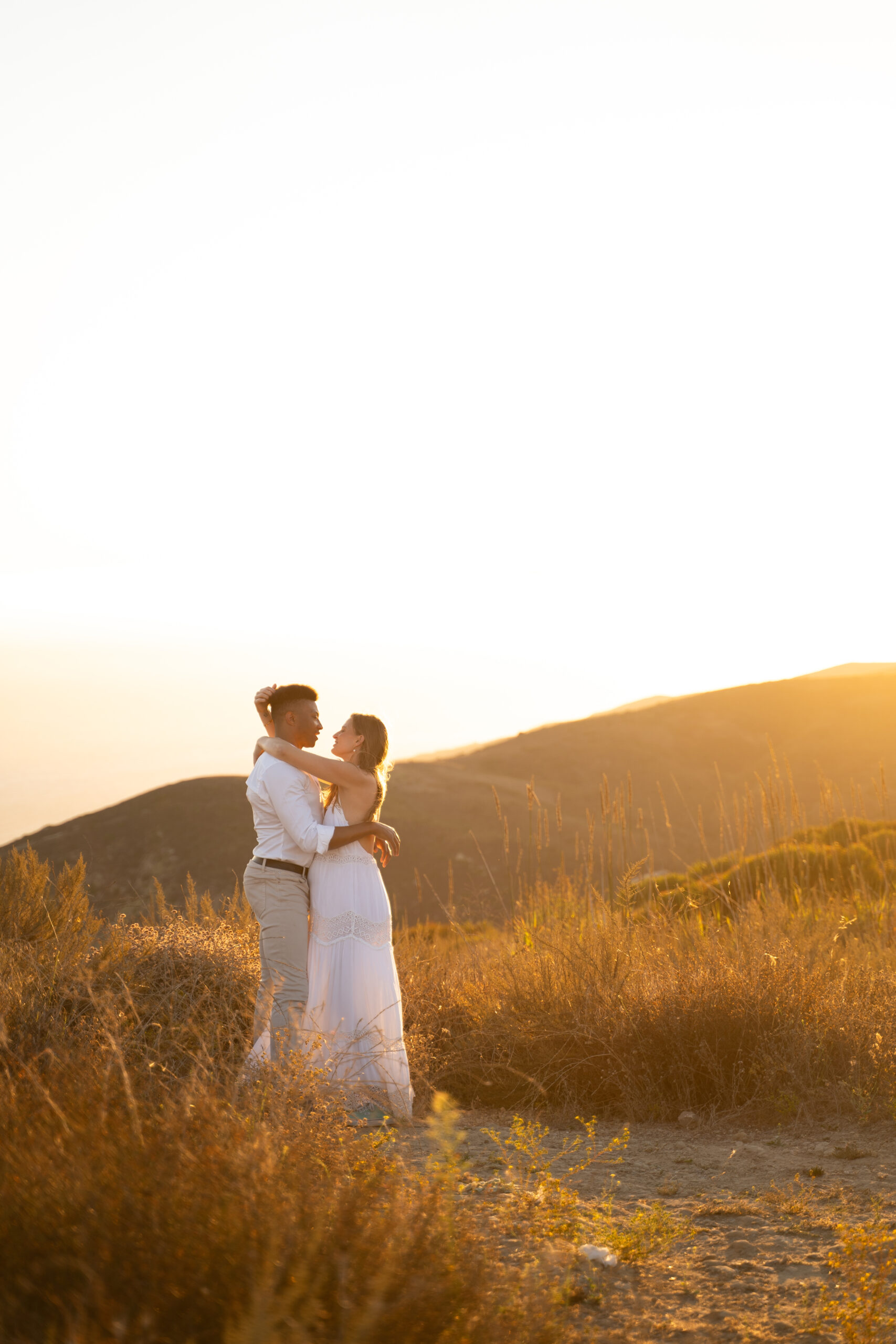 Couple embraces during their elopement in Malibu at sunset.